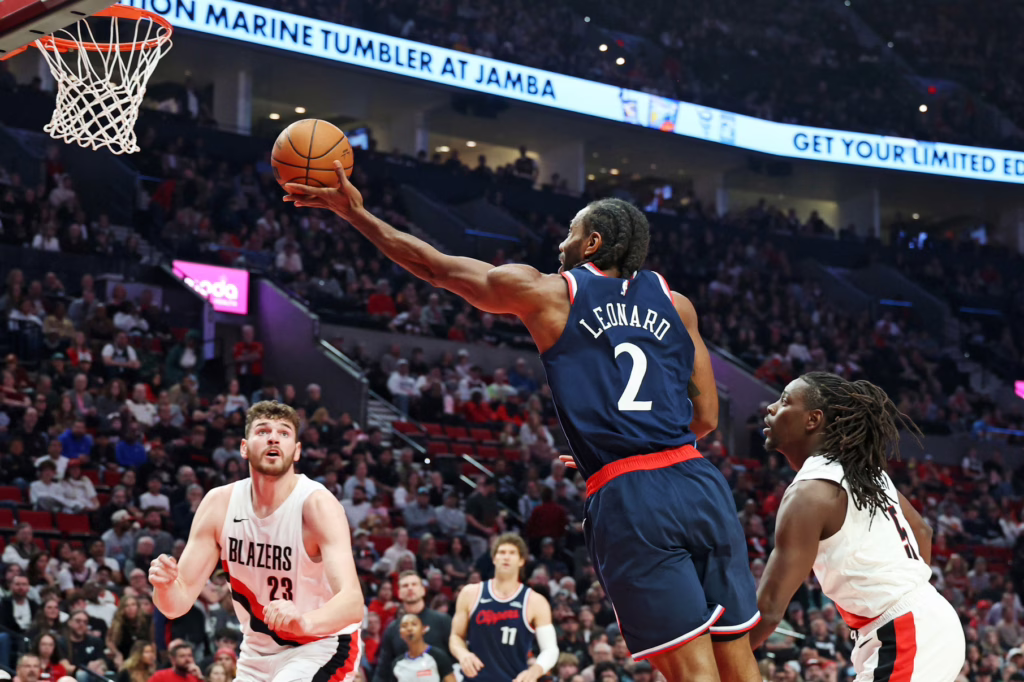 LA Clippers forward Kawhi Leonard (2) shoots the ball over Portland Trail Blazers center Donovan Clingan (23) and guard Jrue Holiday (5) during the first half at Moda Center.