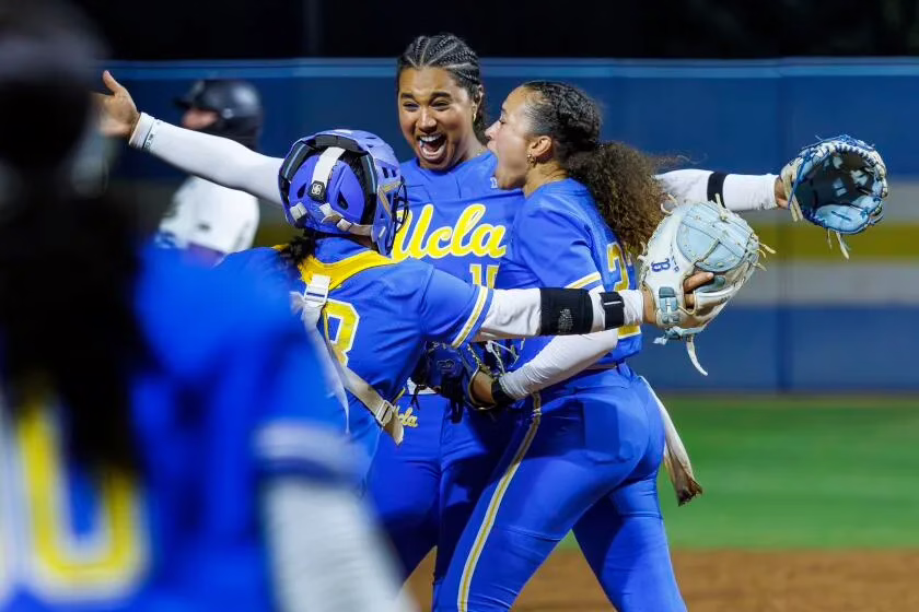 UCLA infielder Jordan Woolery (15) celebrates with Bruins catcher Alexis Ramirez (28) and pitcher Taylor Tinsley (23) after beating UCF Saturday to reach the Women's College World Series.