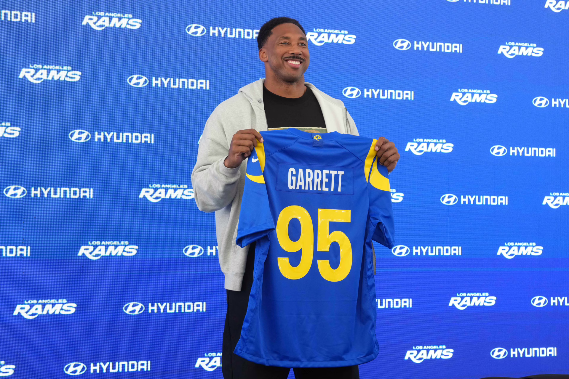 Jun 2, 2026; Woodland Hills, CA, USA; Los Angeles Rams defensive end Myles Garrett (95) poses with jersey at press conference at Rams Practice Facility. Mandatory Credit: Kirby Lee-Imagn Images